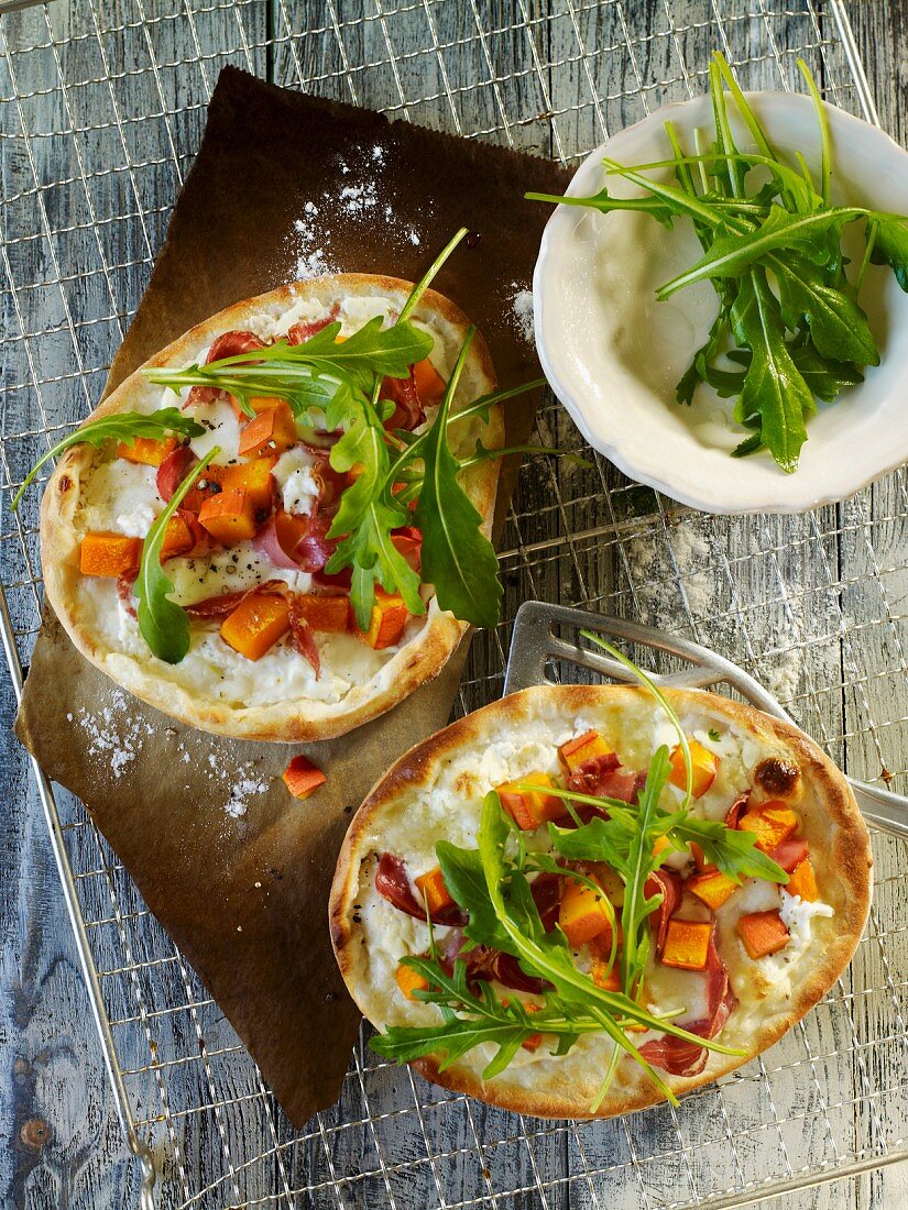 Mini pizzas with squash, bacon and rocket