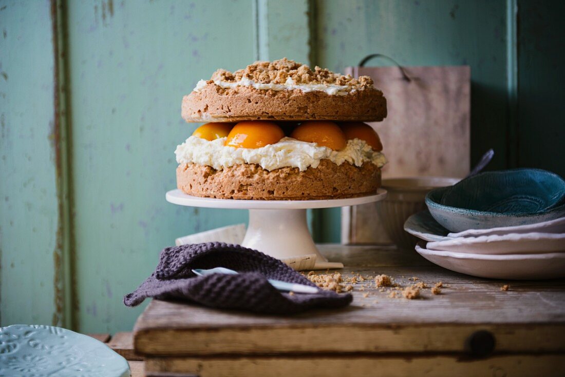 Peach layer cake with cream cheese filling and oat crumble topping