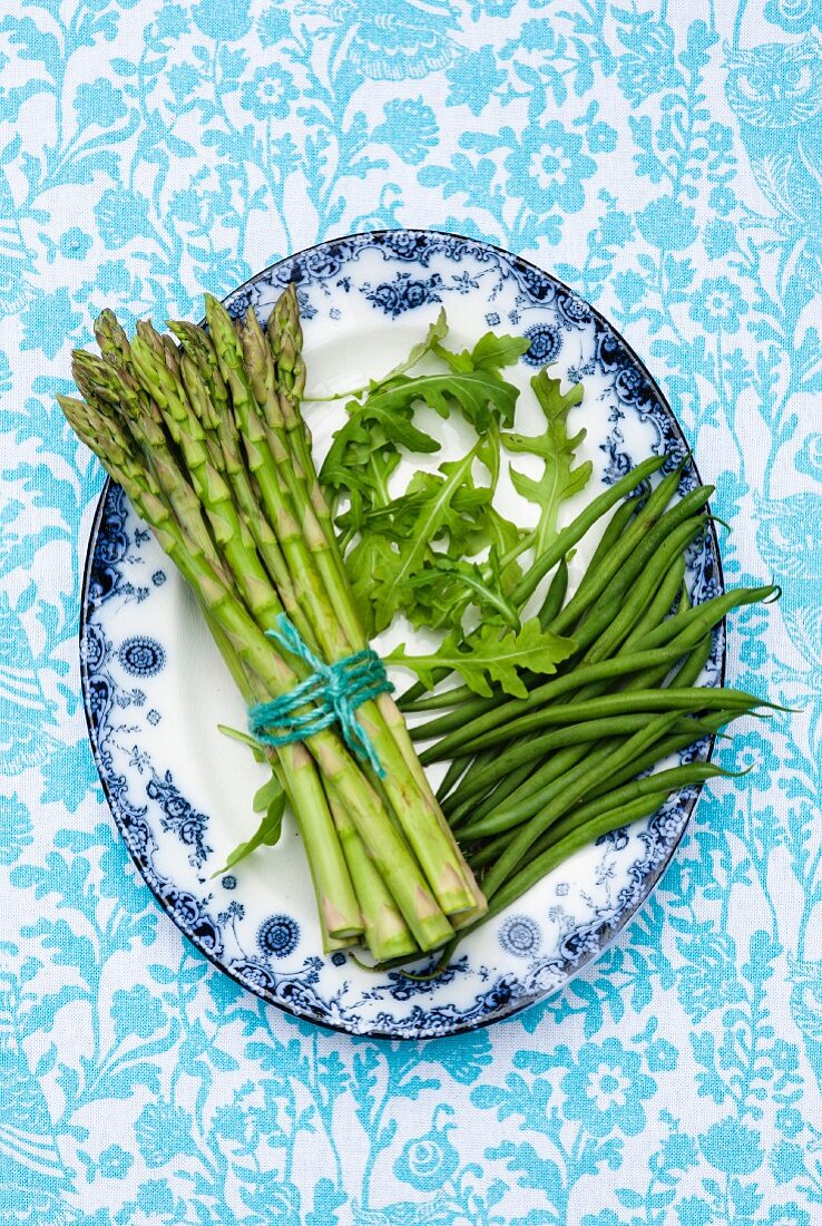 Grüner Spargel, Rucola und Bohnen auf gemustertem Teller