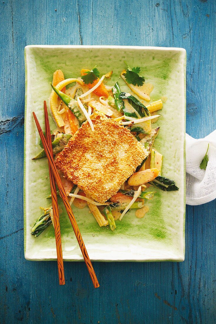 Tofu with a sesame crust on a bed of vegetables