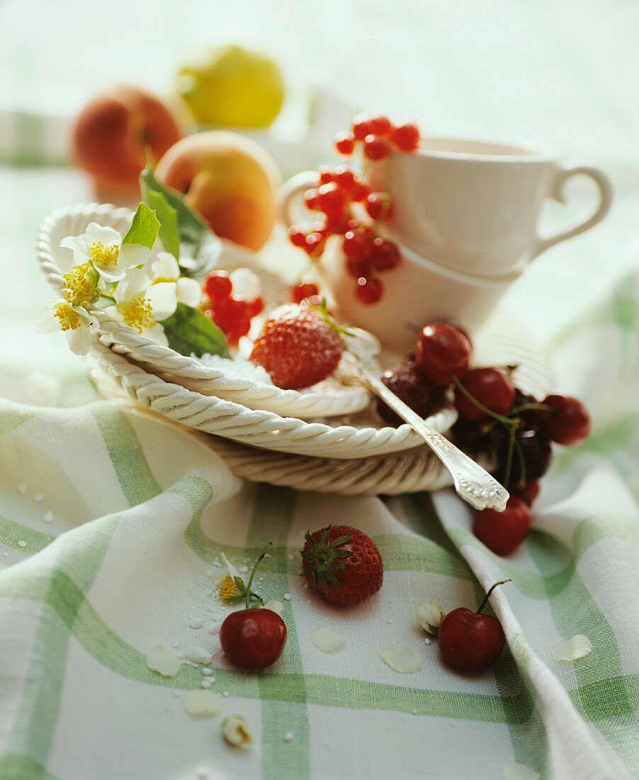 Stillleben mit frischen Früchten, Tassen & Tellern auf Tisch