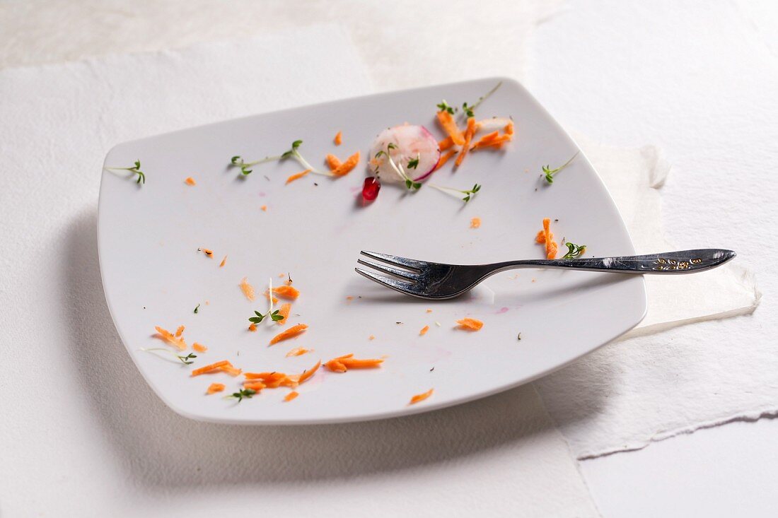 The remains of carrots and cress on a plate