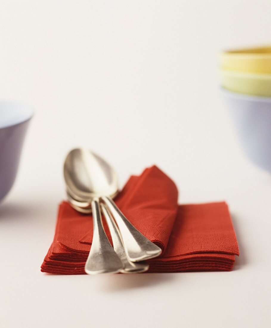 Soup spoons on a stack of red paper napkins