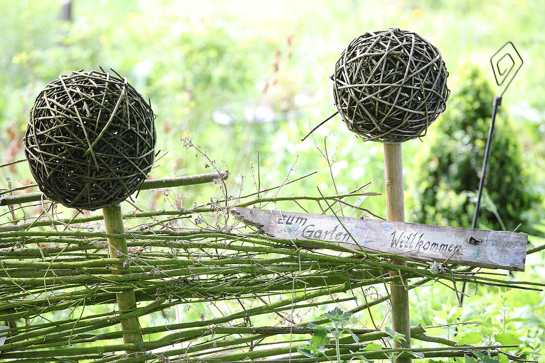 Gartenschild am selbstgemachten Zaun mit Weidenkugeln