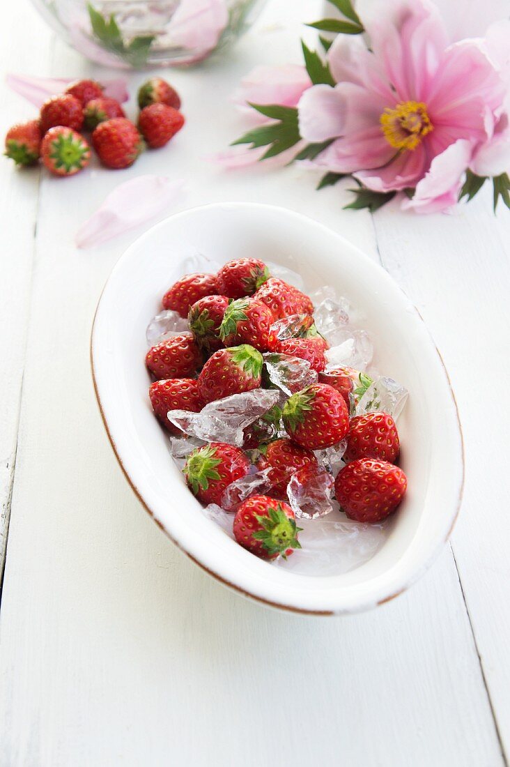 A plate of strawberries and lime ice cubes