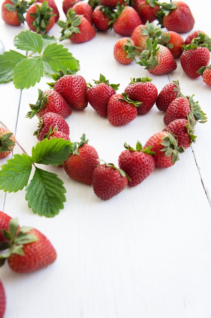 A heart made of strawberries with leaves