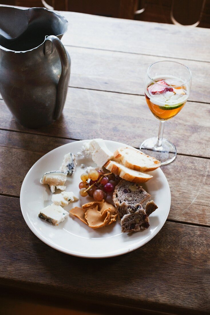 Assorted Fresh Cheeses on a White Plate with Grapes and A Glass of Sangria