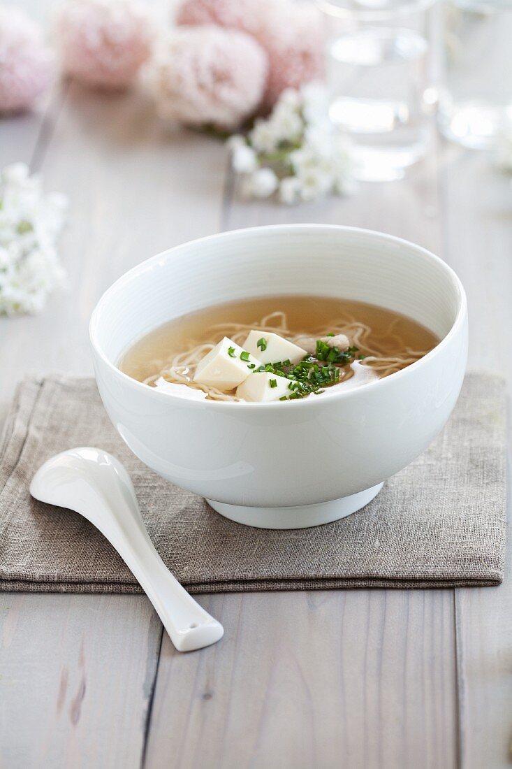 Chicken broth with tofu, noodles and chives