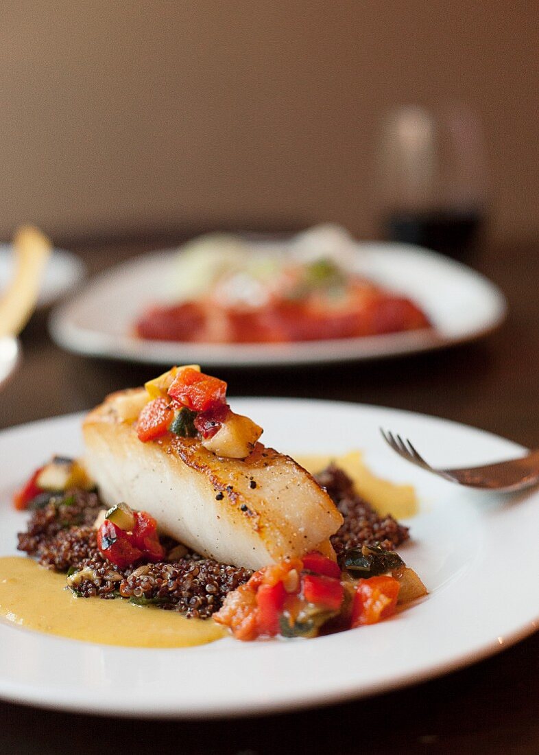 Gebratenes Fischfilet auf Gemüse und Quinoa