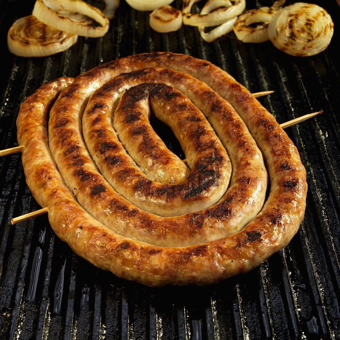 Coil of Italian Sausage on Grill with Onions