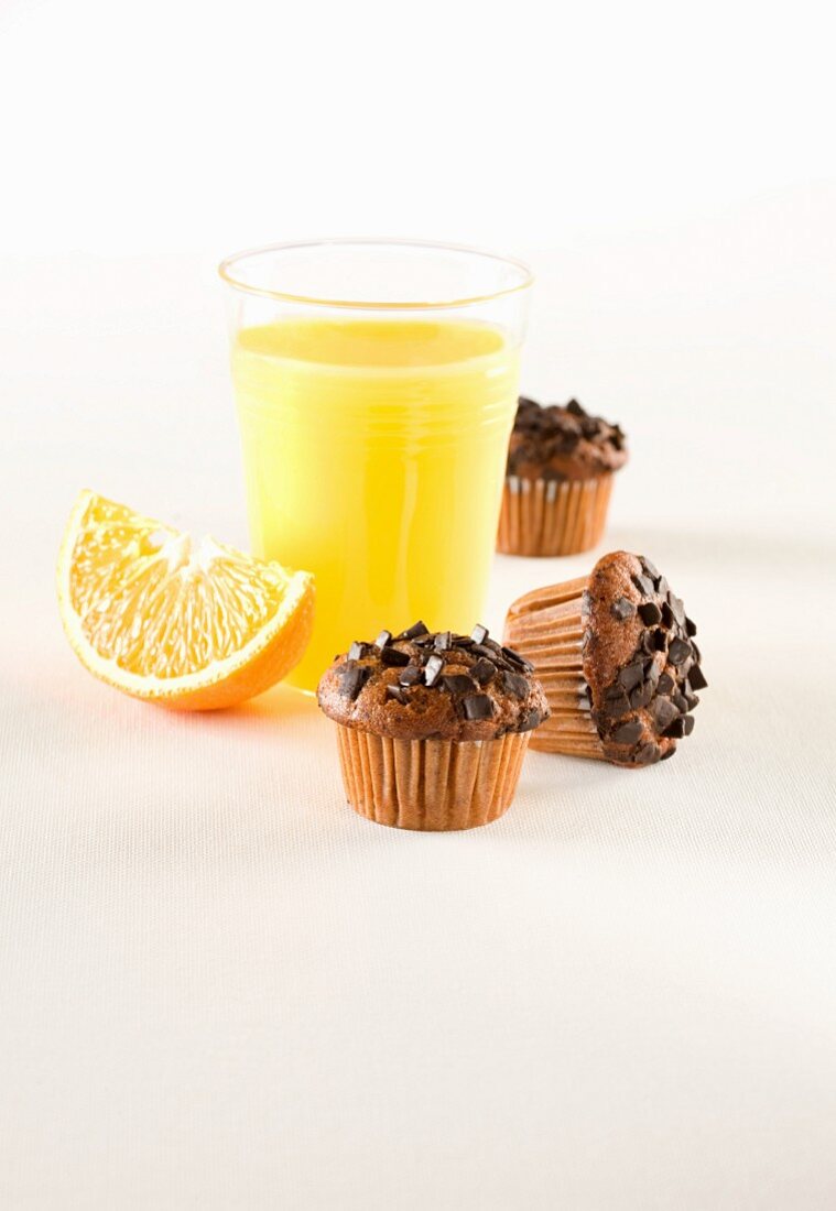 Muffins mit Schokostreuseln; dazu frisch gepresster Orangensaft