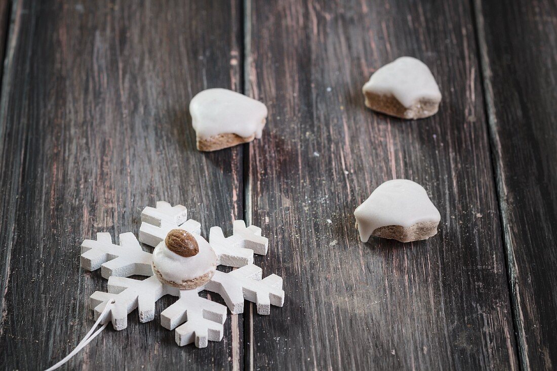 Bell shaped, pfeffernüsse (gingerbread) cookies and a pfeffernuss cookie decorated with an almond on top of a star shaped ornament