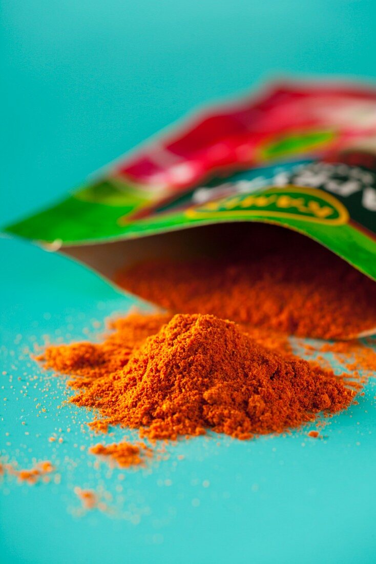 Ground paprika in front of and in a paper packet