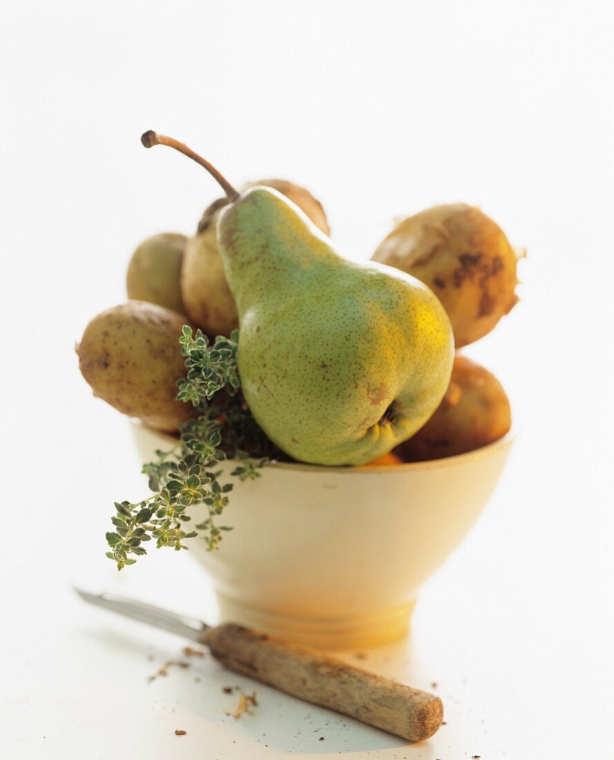 Potatoes, pears and thyme in a bowl