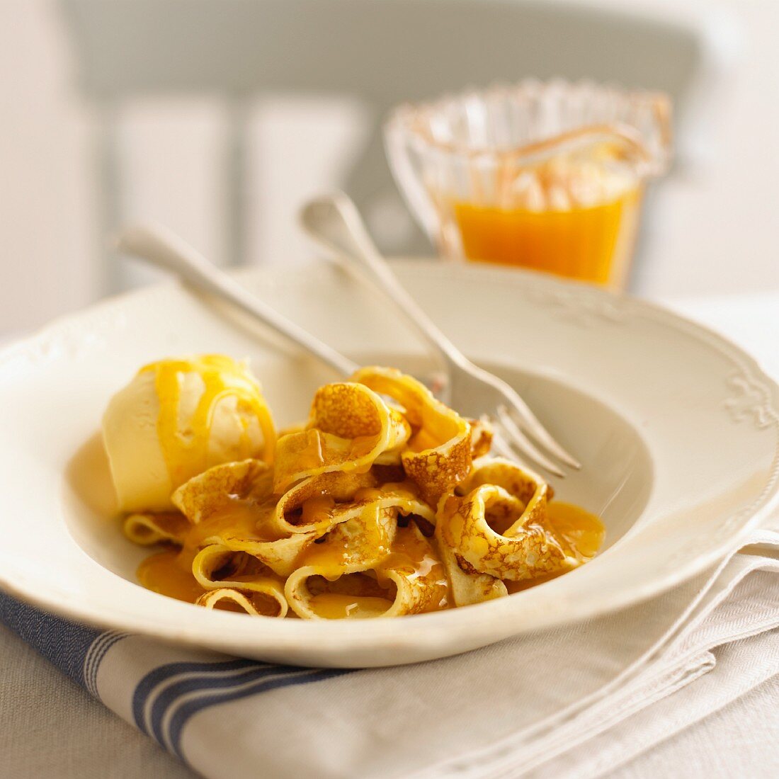 Pfannkuchenstreifen mit Orangensauce und Vanilleeis