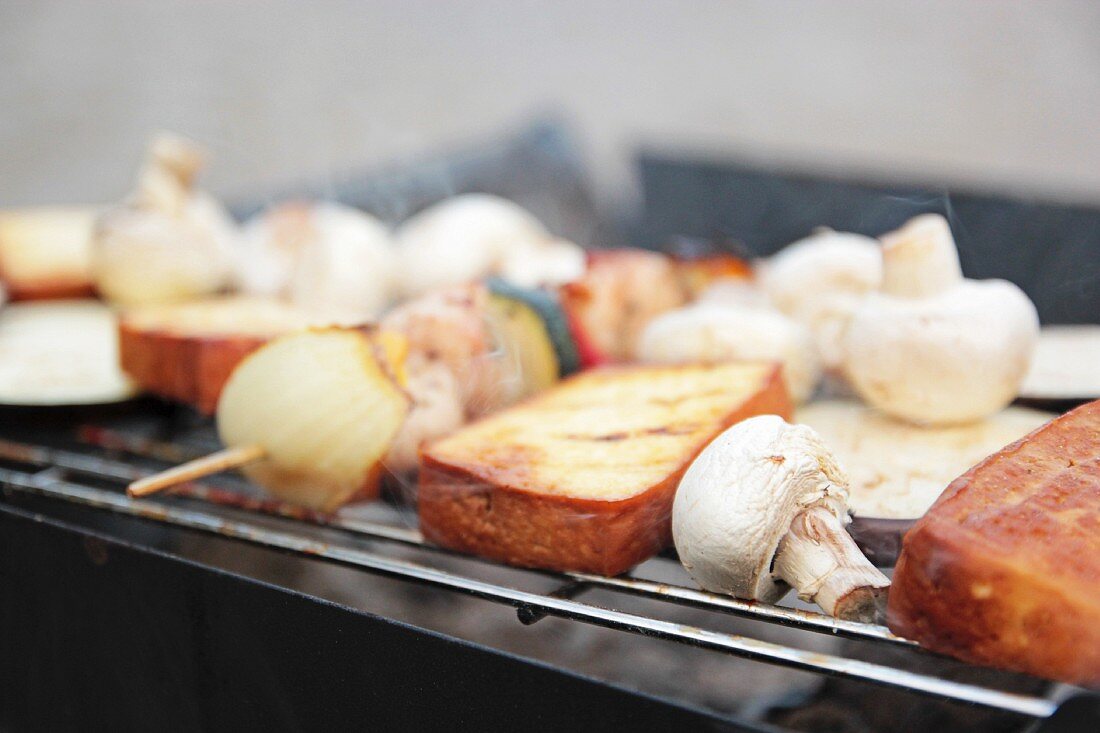 Tofuscheiben und Gemüsespiesse mit Zucchini, Zwiebel, Pilzen und Auberginen auf dem Grill