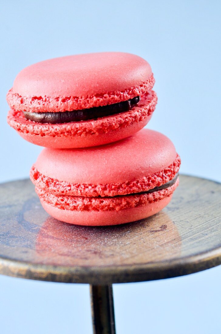 Two raspberry macarons with chocolate filling