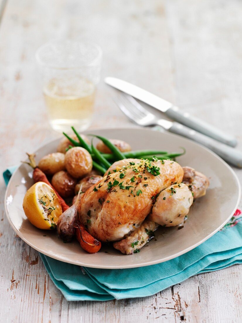 Roast spring chickens with lemons, potatoes and sliced peppers