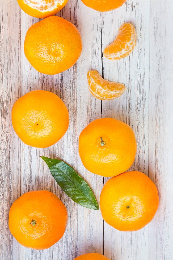 Sections of and whole clementine oranges and a leaf