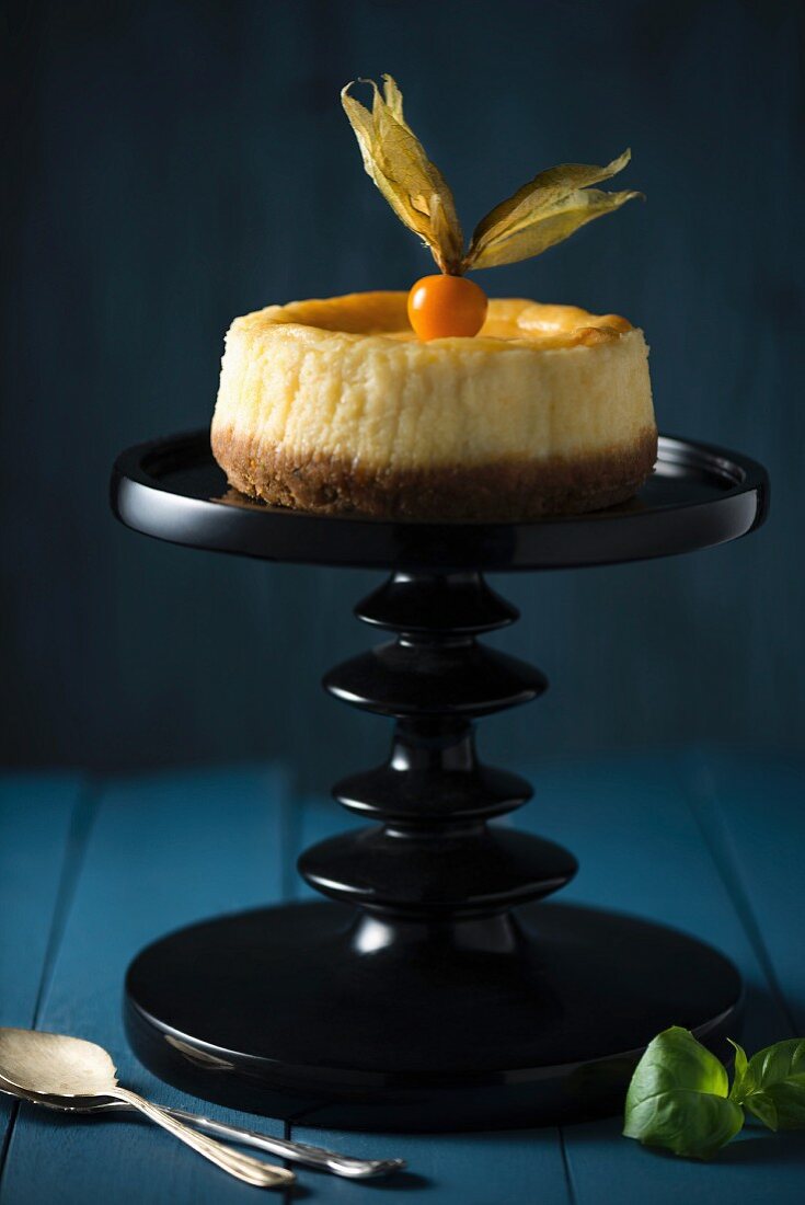 Lemon cheese cake with physalis on a cake stand