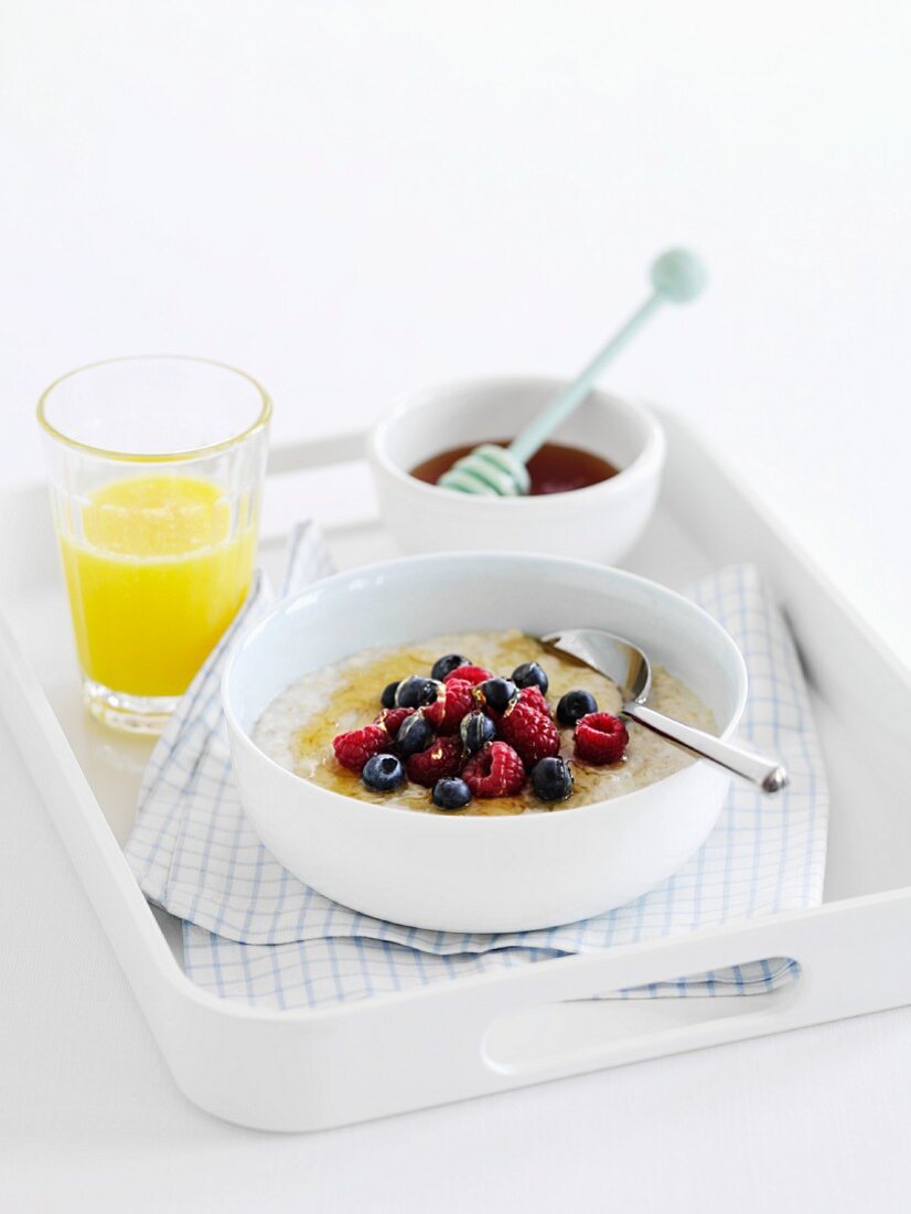 Haferbrei mit frischen Beeren, Honig und Orangensaft