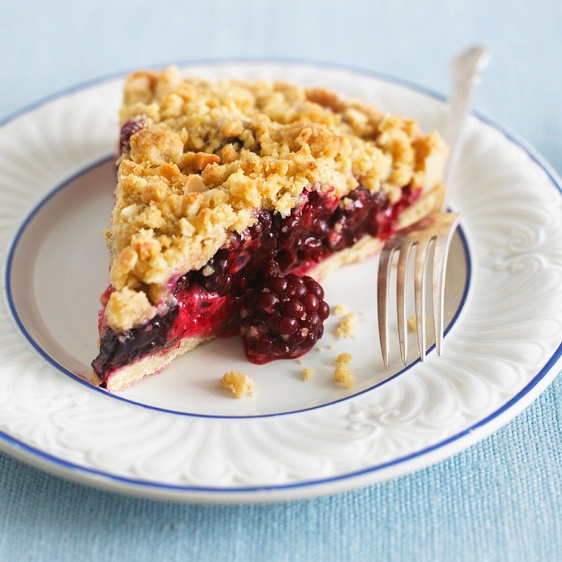 Ein Stück Brombeer-Apfel-Tarte mit Streuseln