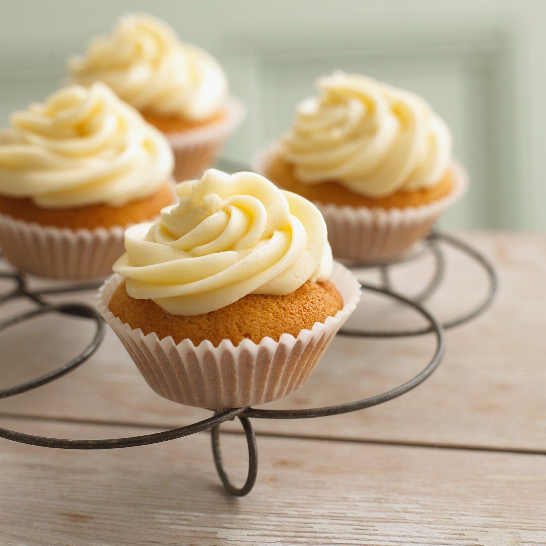 Cupcakes mit Vanillecreme auf Kuchengitter