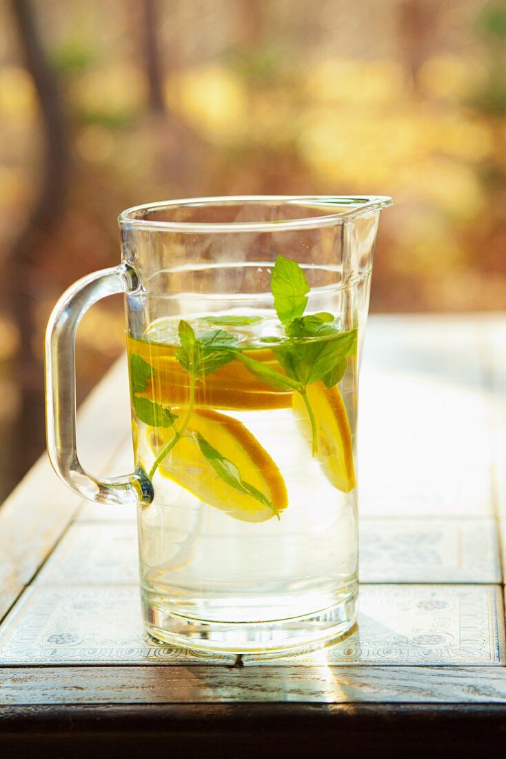 Lemonade with lemon slices and mint in a glass jug