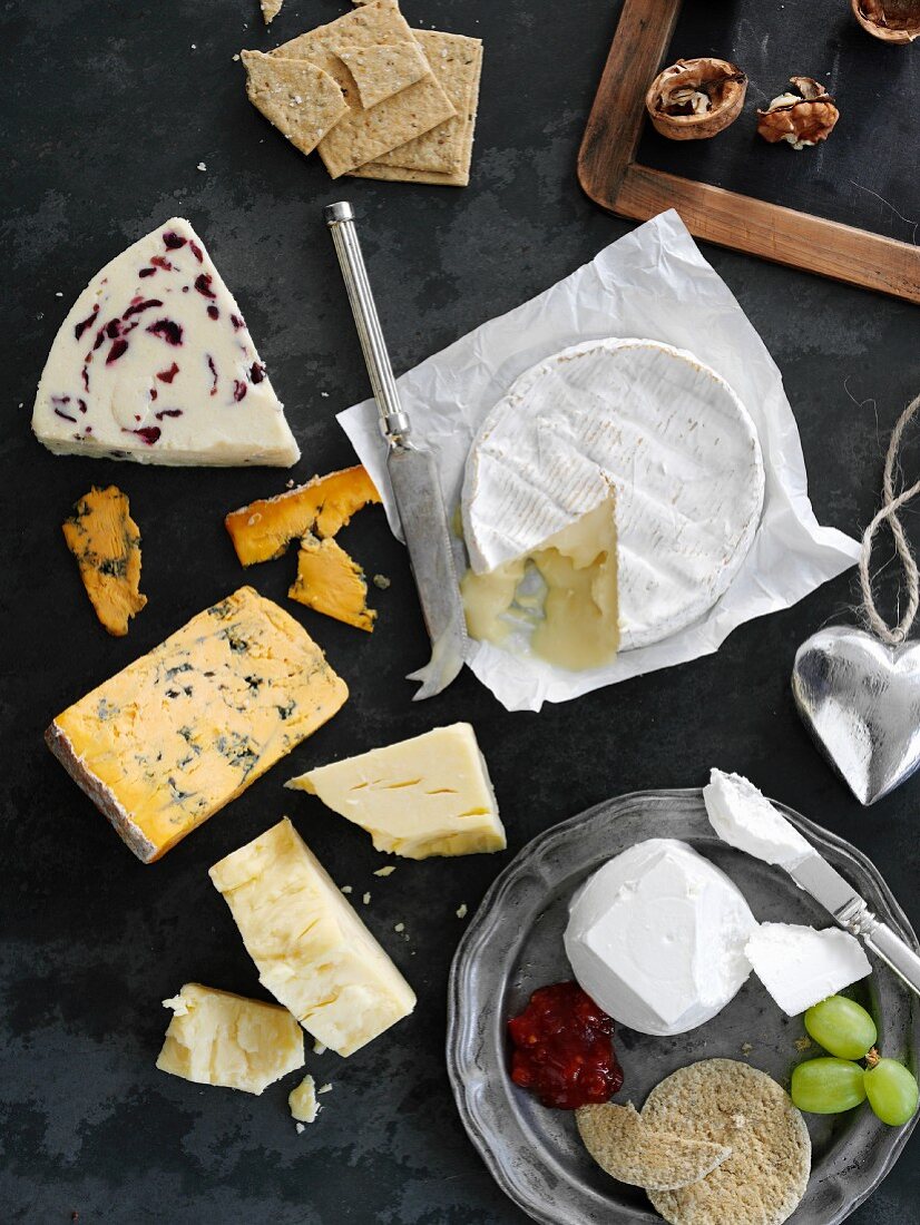 Assorted varieties of cheese with crackers, walnuts and grapes