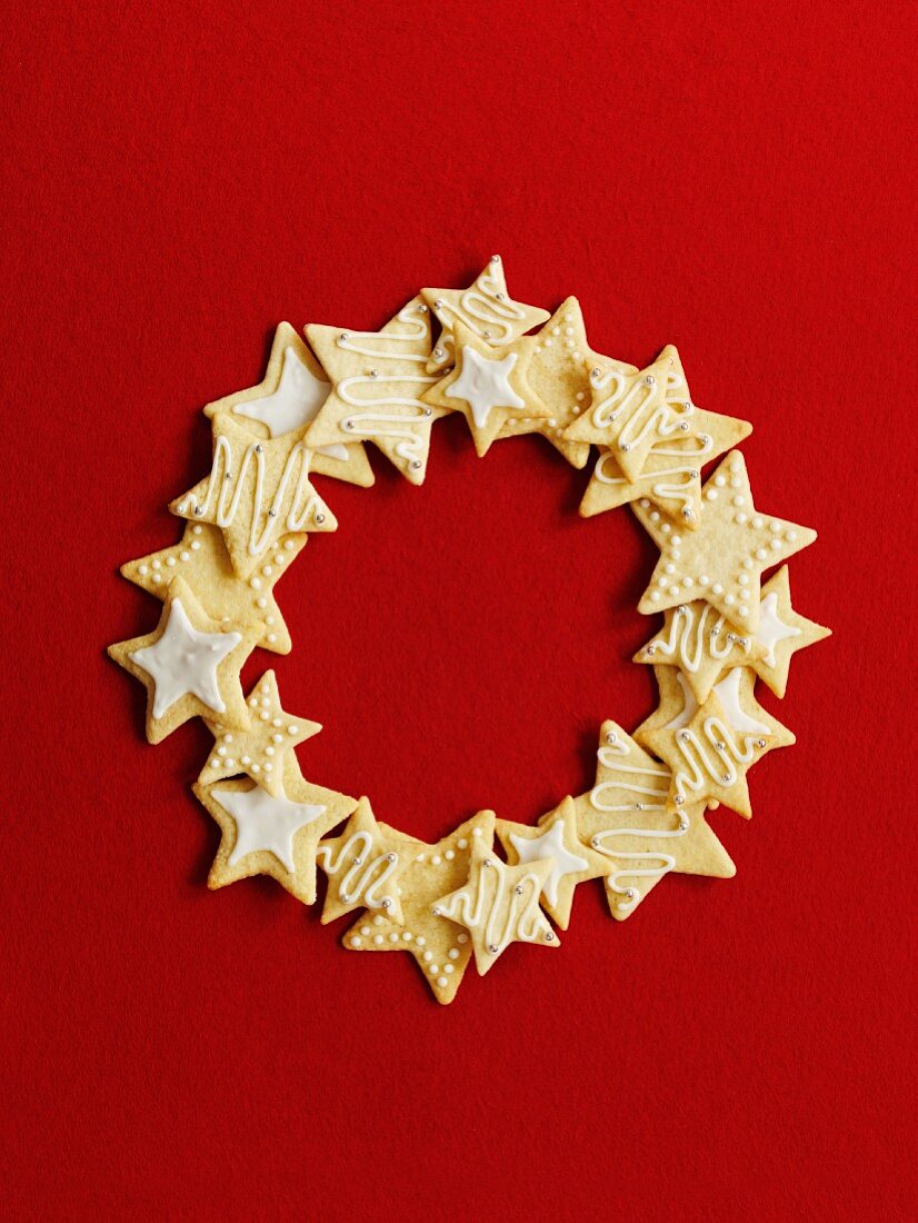 Wreath made of star cookies in front of a red background