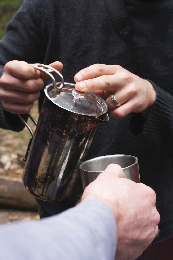 Pouring Coffee into a Metal Cup