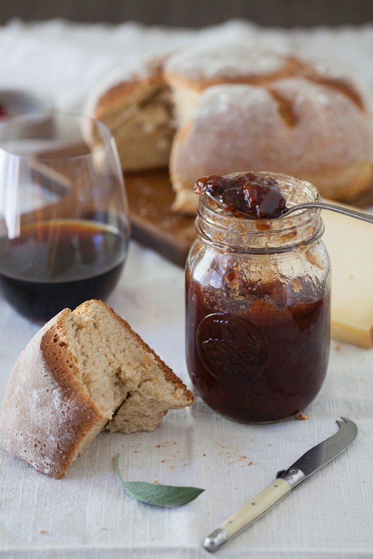 Ein Glas Pflaumenmus mit Brot und Wein