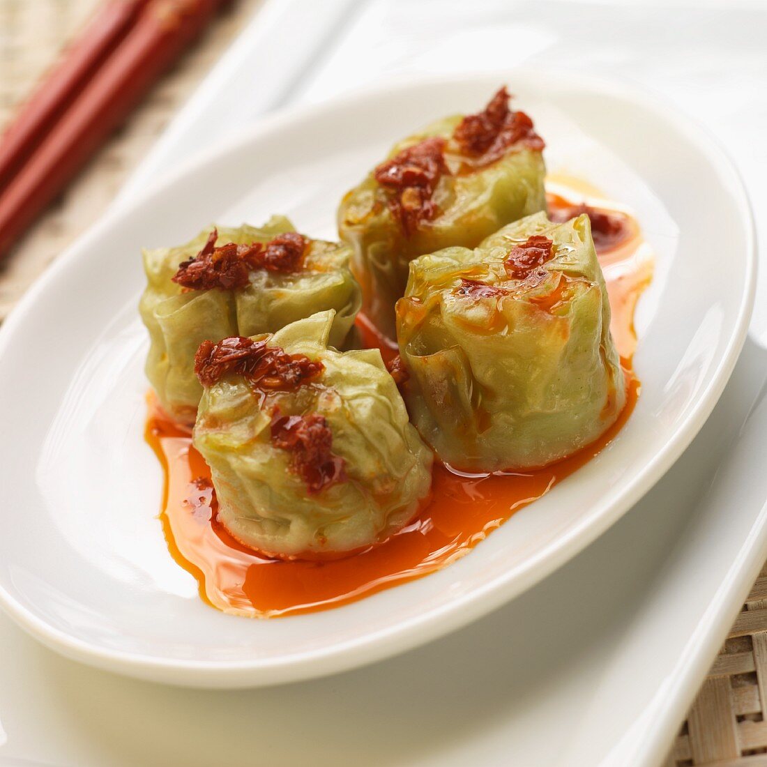 Four Edamame Shumai (Soy Bean Dumplings), on White Plate with Red Pepper Oil