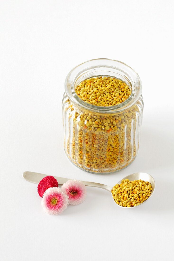 Flower pollen in a small jar and on a spoon