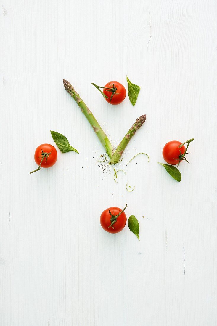 Eine Uhr aus Tomaten und grünem Spargel