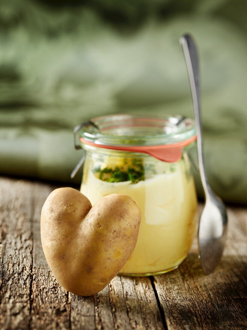 Herzförmige Kartoffel an Einmachglas mit Kartoffelpüree
