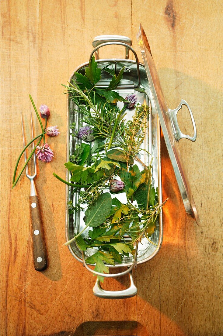 Fresh herbs in a fish cooking dish with insert