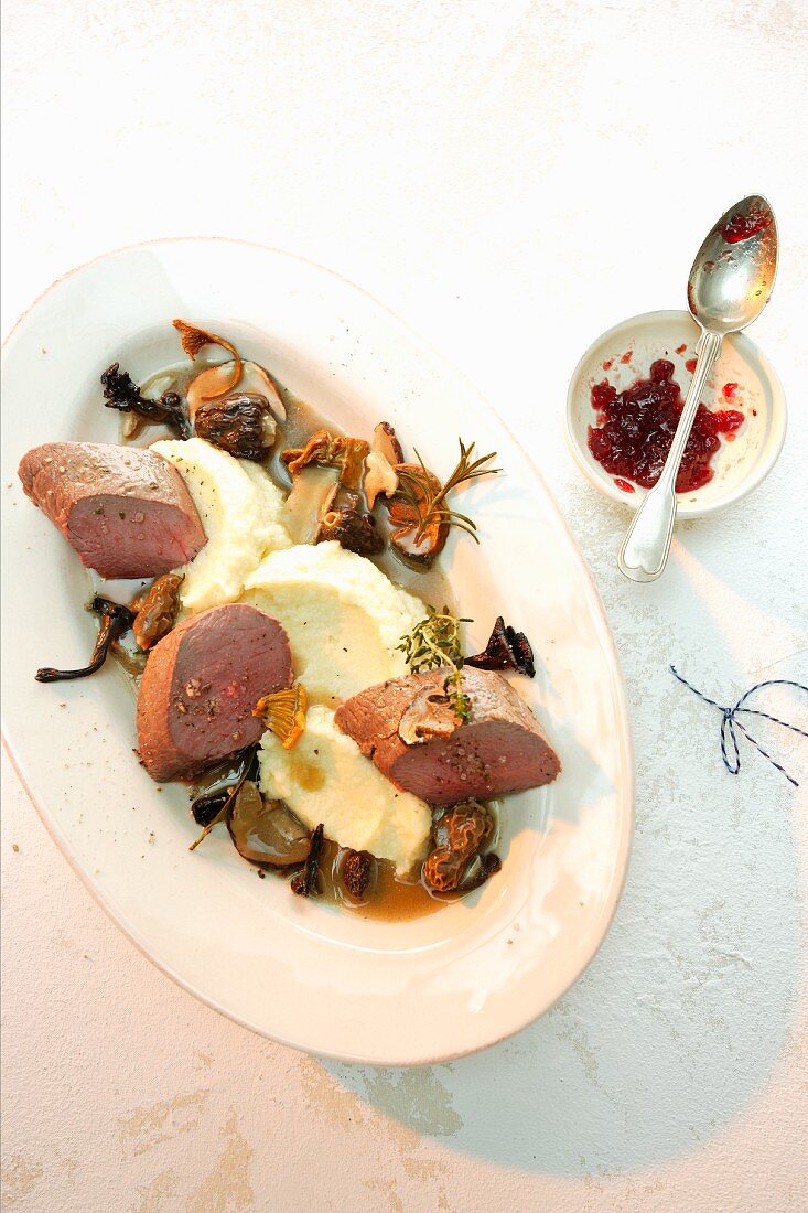 Saddle of venison on mashed potato with mushrooms and cranberry jam