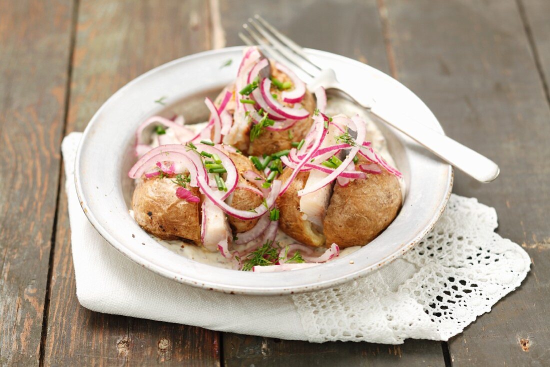 Baked potatoes with herring and red onions