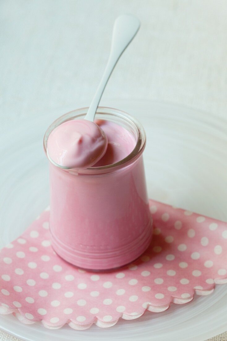 Strawberry yoghurt in a jar with a spoon