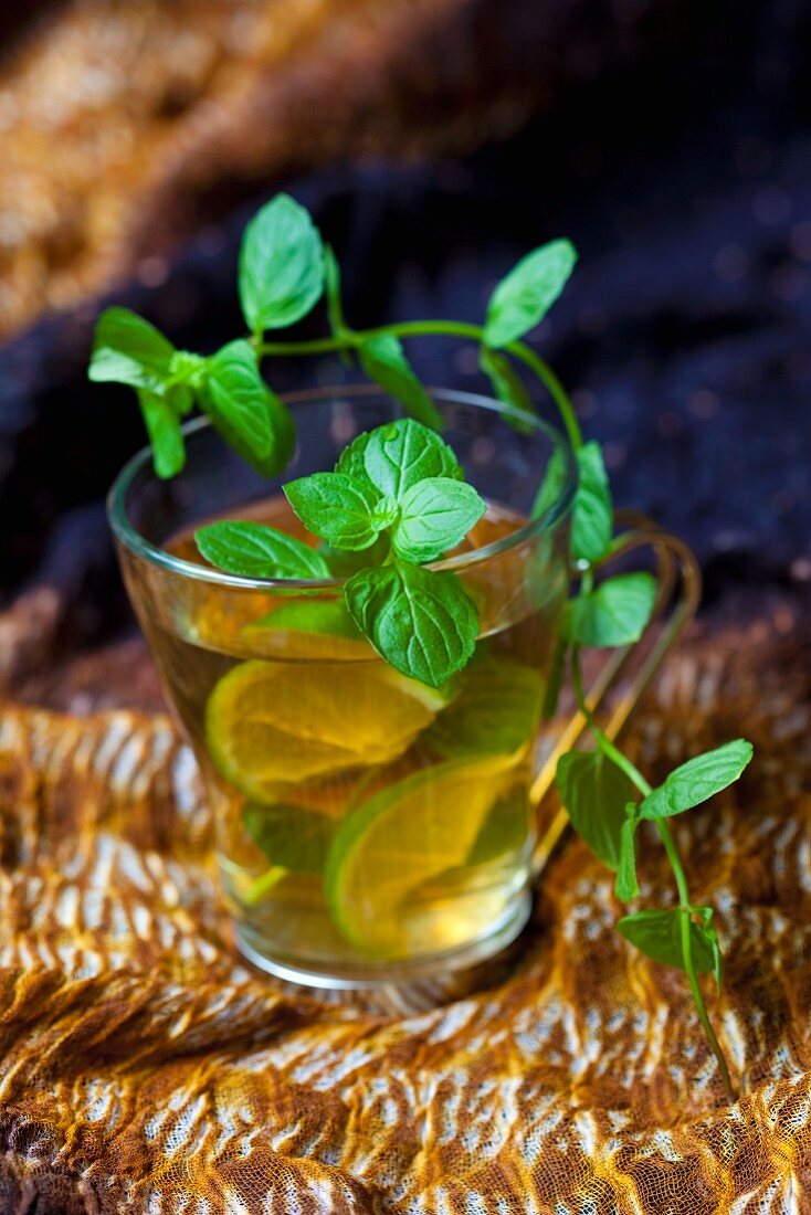 A glass of peppermint tea with lime slices