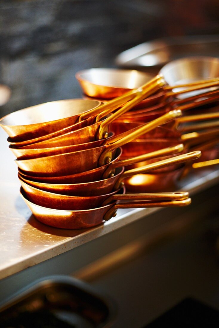 Gestapelte Kupferpfannen in einer Restaurantküche