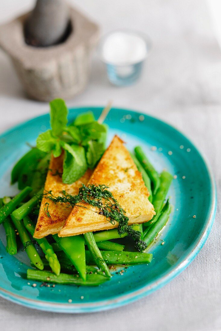 Lemon tofu on a bed of asparagus and beans