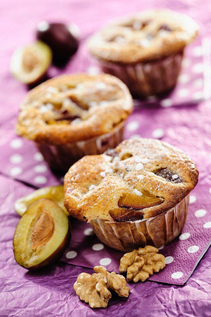 Plum and Walnut Muffins on purple background, selective focus