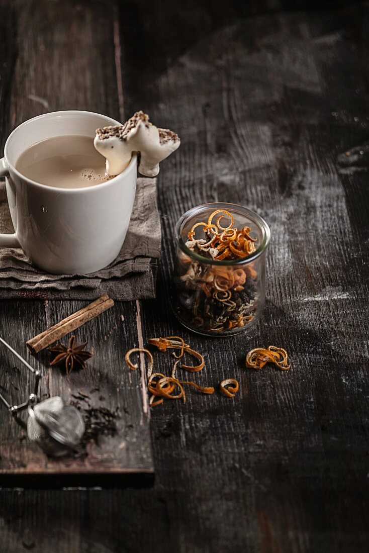 Masala chai in a cup with biscuits and chai spices in a glass