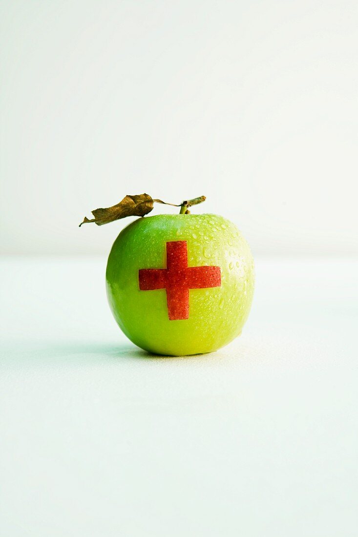 An apple with a red cross
