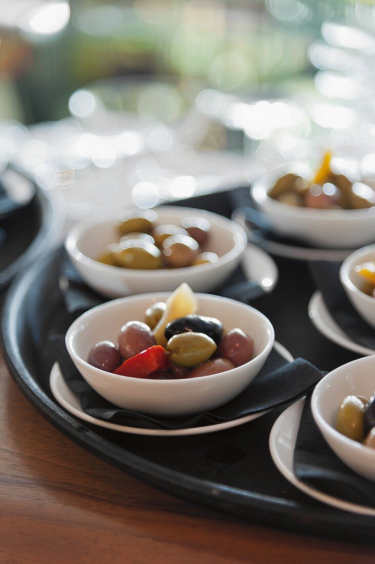 Marinated olives in bowls in a tray