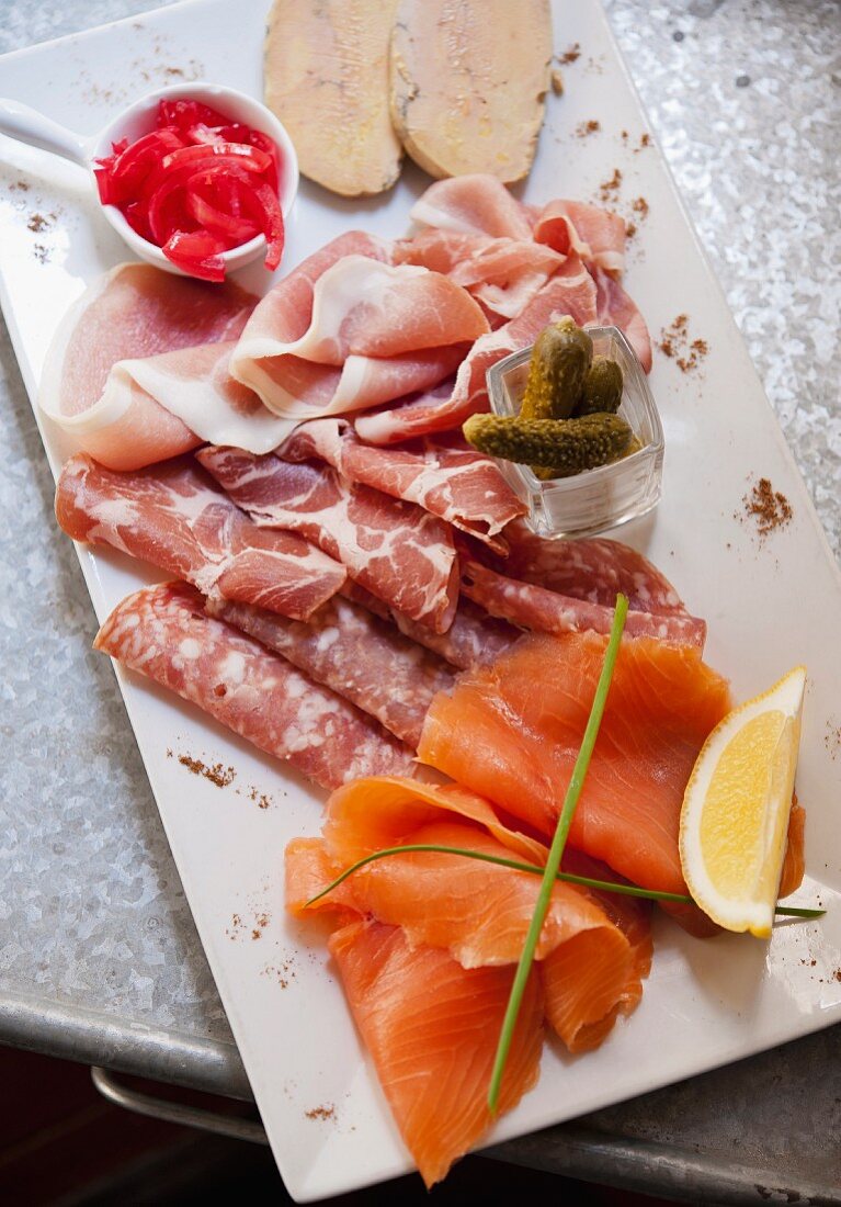 A platter of sausage with salmon, goose liver and pickled gherkins (Italy)