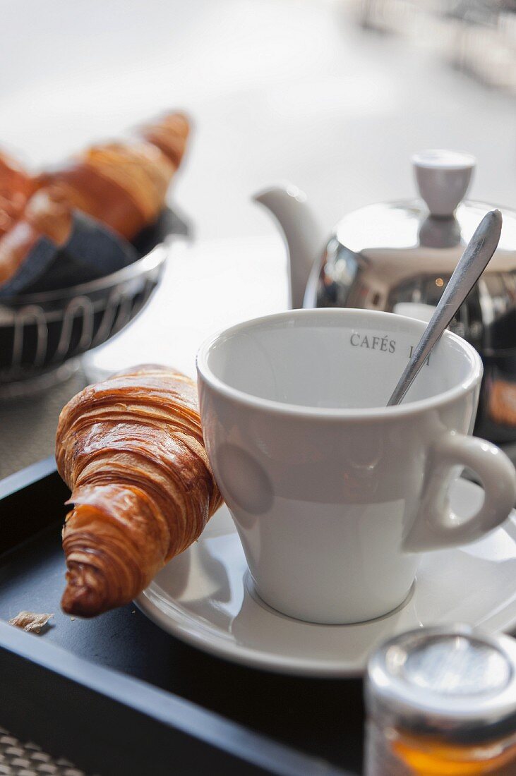 Croissant, Kaffee und Honig zum Frühstück