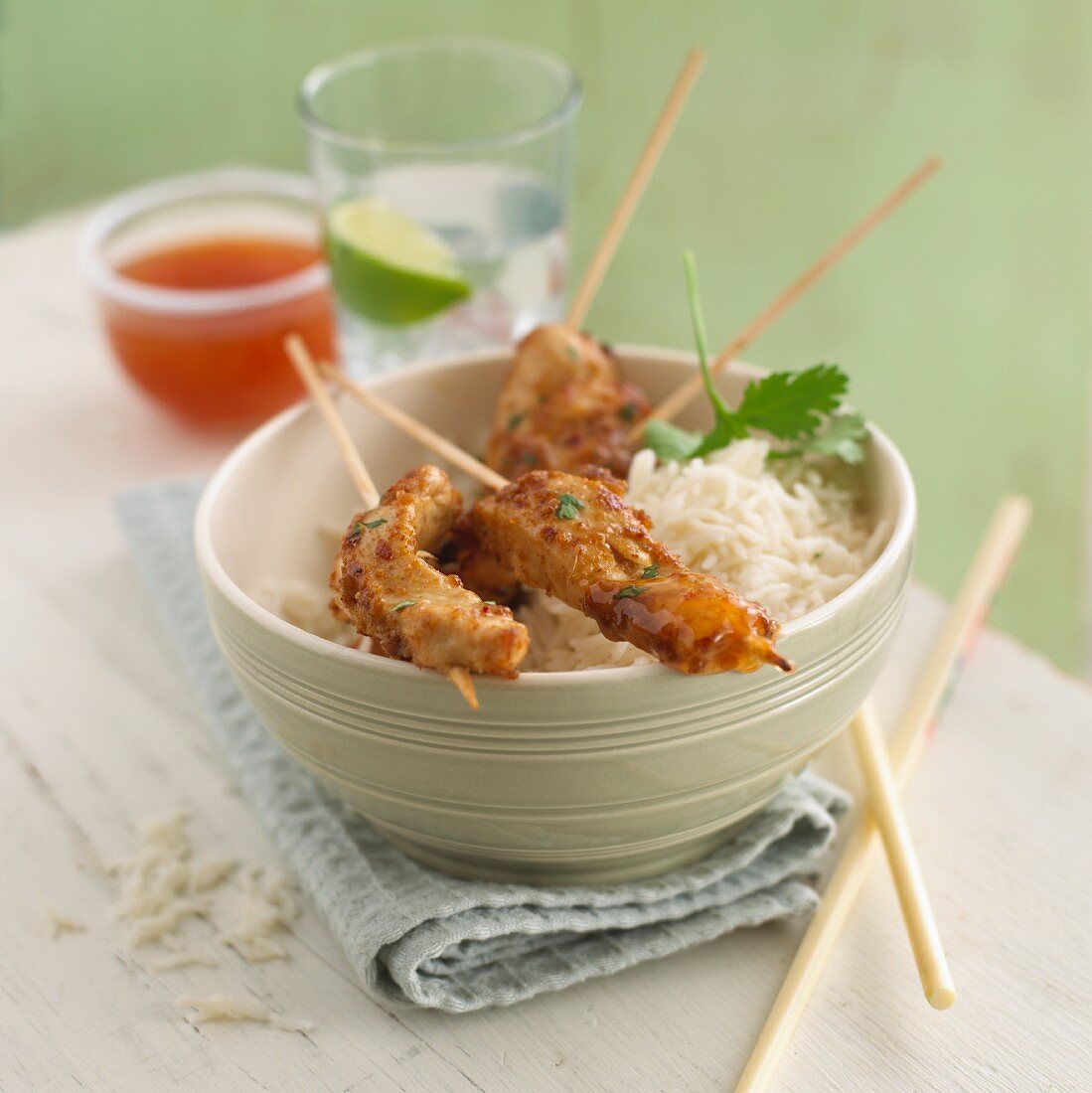 Chicken satay skewers on a bed of rice